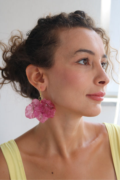 Woman wearing pink earrings with a neutral background
