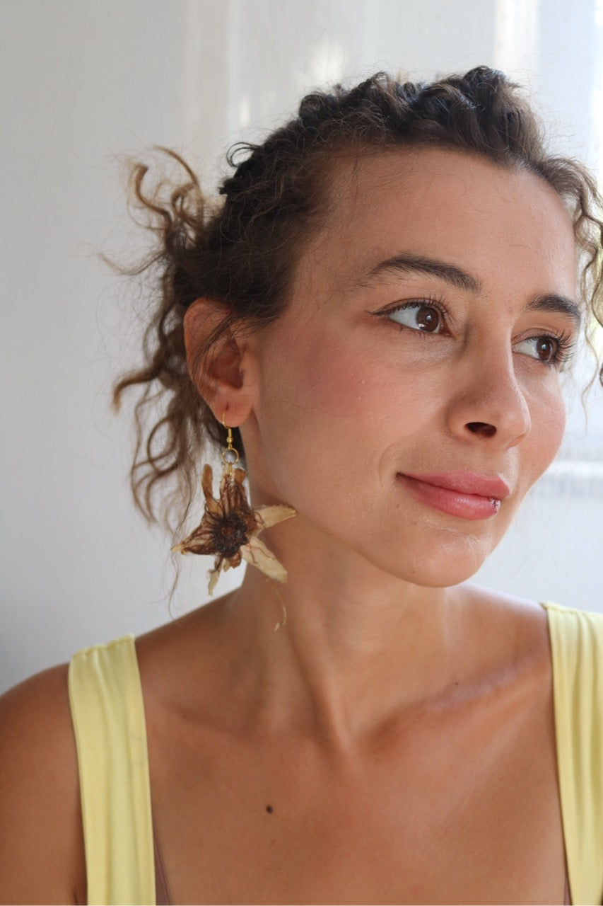 Woman wearing large earrings with a neutral background